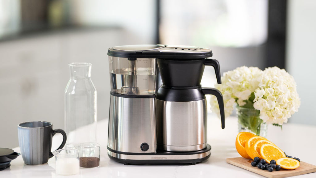 The 8-cup coffee brewer sits atop a modern marble kitchen counter.