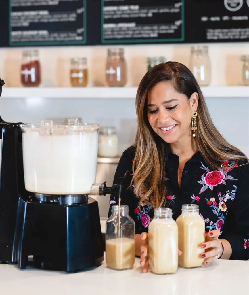 A woman prepares batches of nut milks for her cafe.