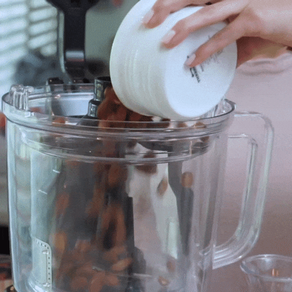 Nuts being poured into the Nutramilk jug.