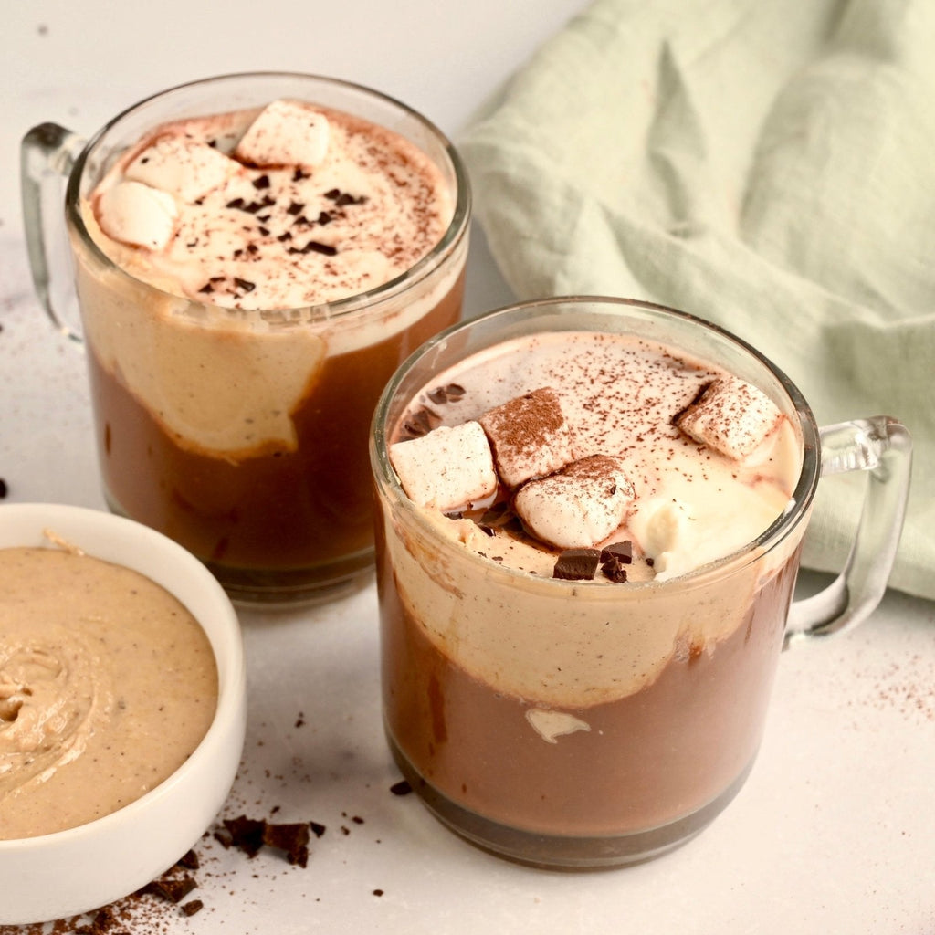 Three mugs of hot chocolate filled with hot cocoa and topped with fluffy white marshmallows
