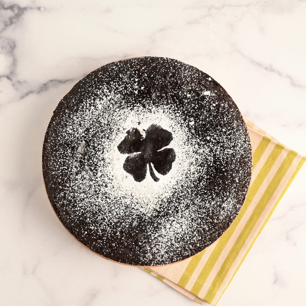 Chocolate cake topped with powdered sugar in the shape of a shamrock