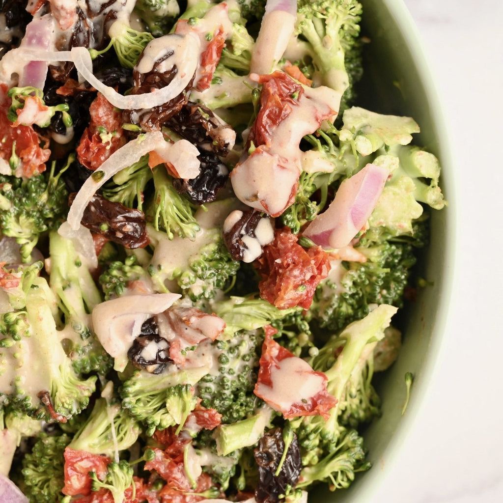 A big bowl full of fresh broccoli and a creamy homemade salad dressing
