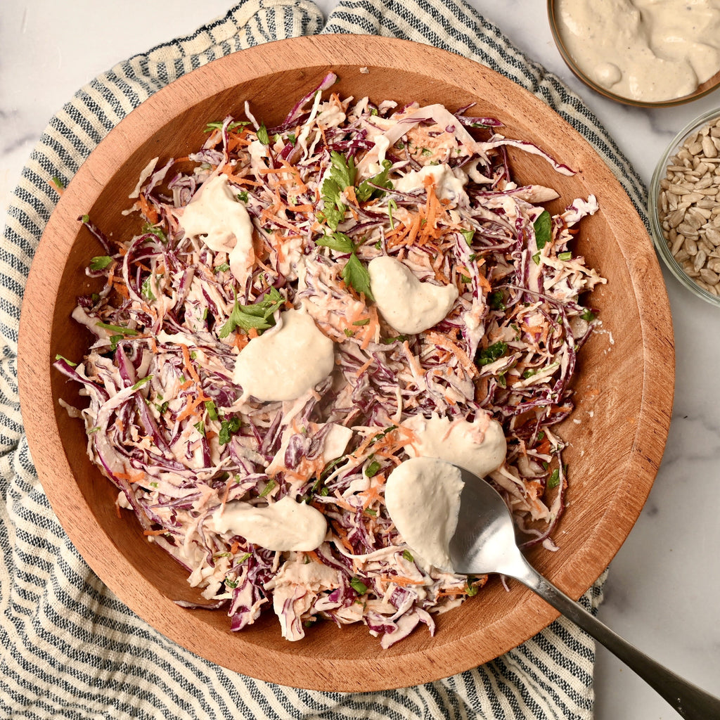 A big wooden bowl filled with homemade coleslaw