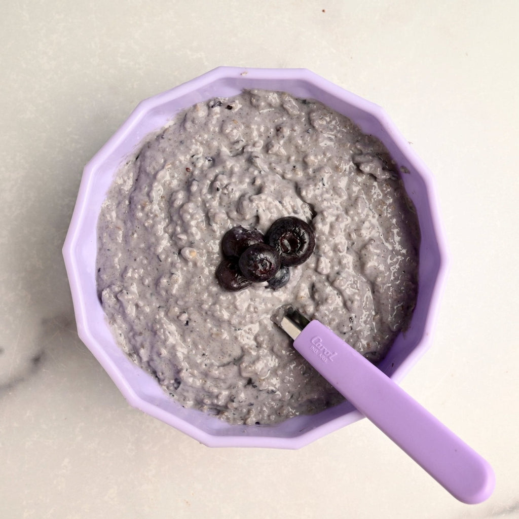 A purple bowl filled with homemade blueberry oatmeal