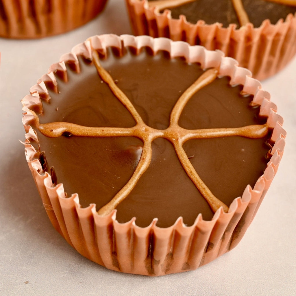 A chocolate nut butter cup with icing in the design of a basketball