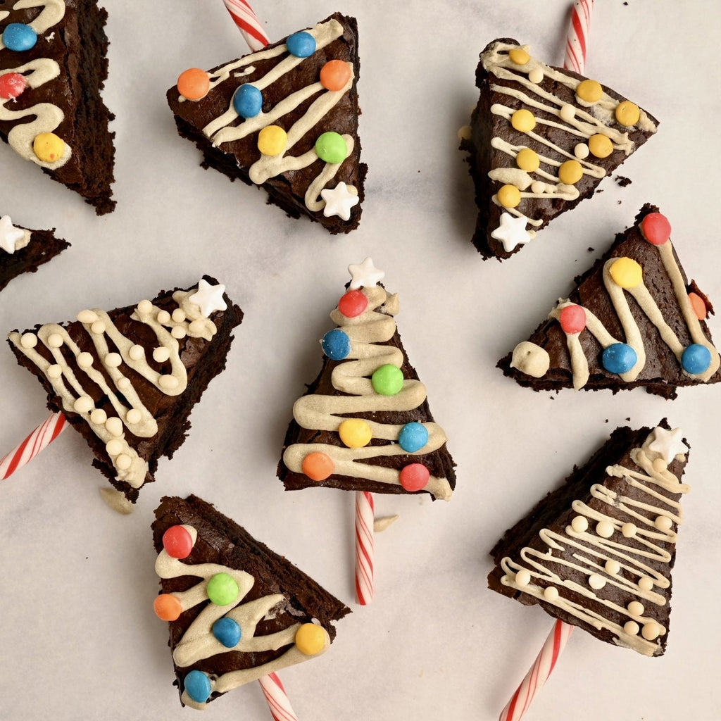 Triangle brownies in the shape of Christmas trees and decorated with icing and candy