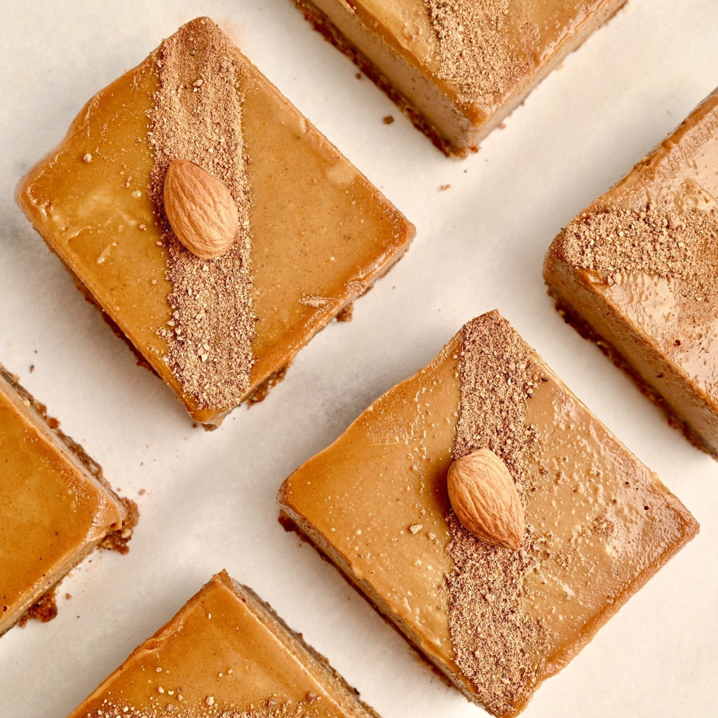 Gingerbread cheesecake bars evenly spaced out on a white background
