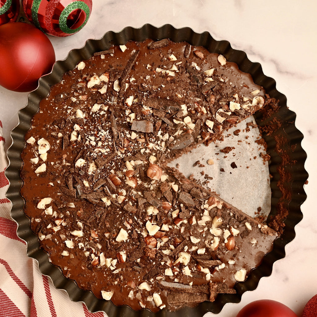 A chocolate tart with crushed hazelnuts on top
