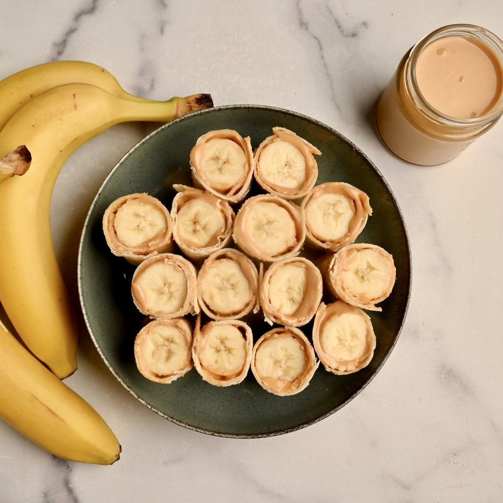 A black plate with homemade peanut butter and banana roll ups
