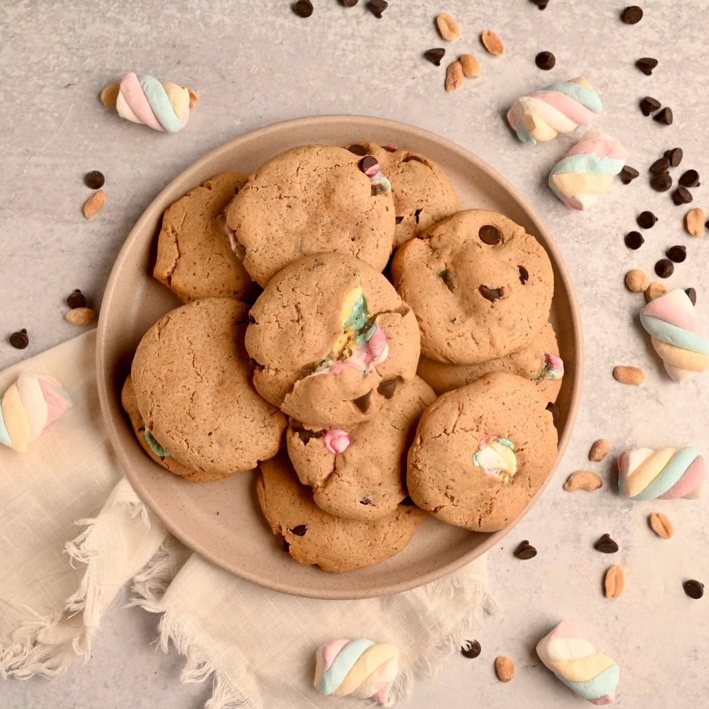 A plate of homemade peanut butter s'more cookies surrounded by pieces of colorful candies