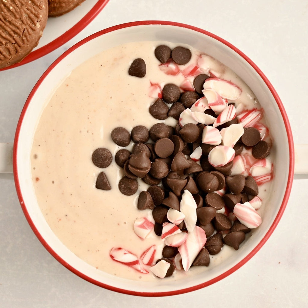 A bowl of peppermint dip topped with chocolate chips and crushed peppermint