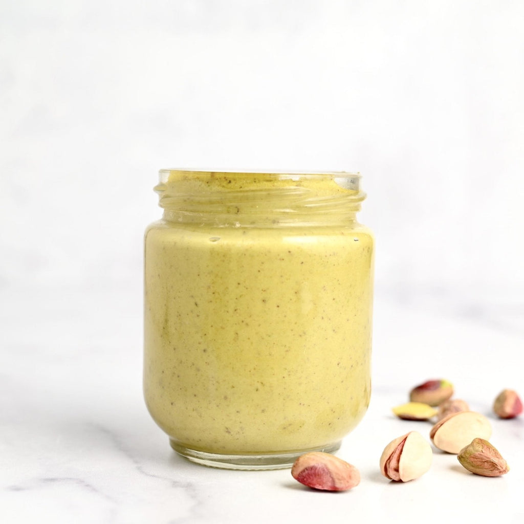 Clear glass jar filled with light green pistachio cream