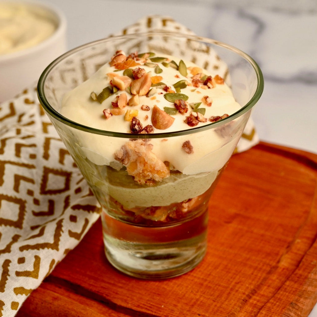 Glass cup filled with green pistachio pudding topped with crushed nuts