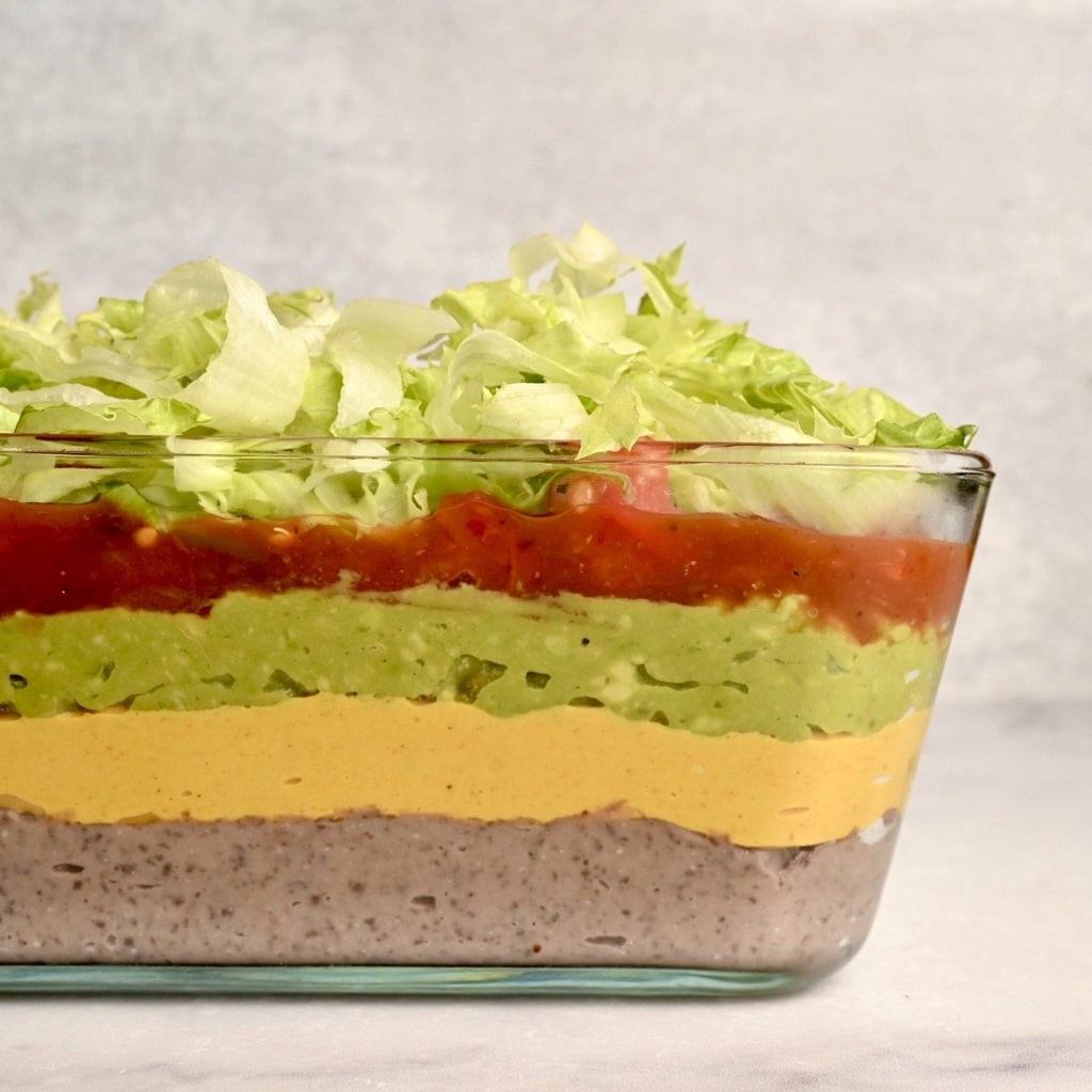 A glass casserole dish with seven layers of different ingredients