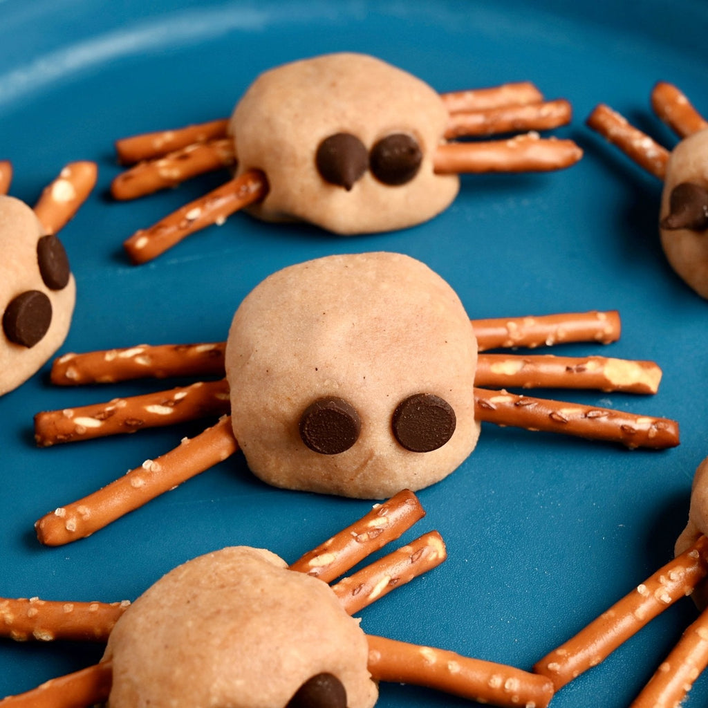 Blue plate with homemade peanut butter spider balls with pretzel legs and chocolate chip eyes