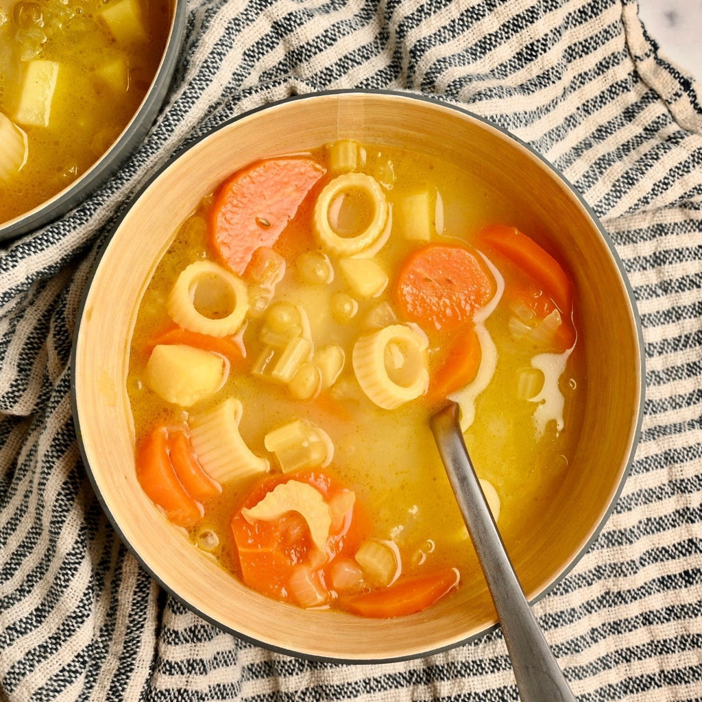 A soup bowl filled with carrots and noodles