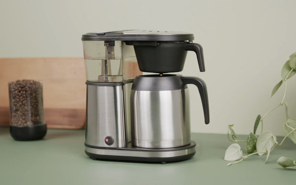 The Bonavita Connoisseur Coffee Brewer sits on a green countertop.