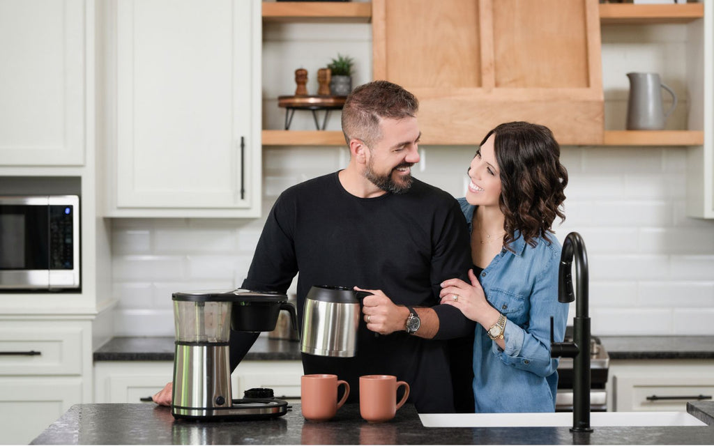 Man and woman making coffee together in their kitchen.