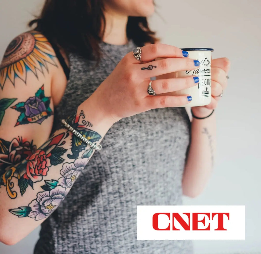 CNET review recommends Bonavita Connoisseur Coffee Brewer. Picture of women with tattoos holding a coffee mug.